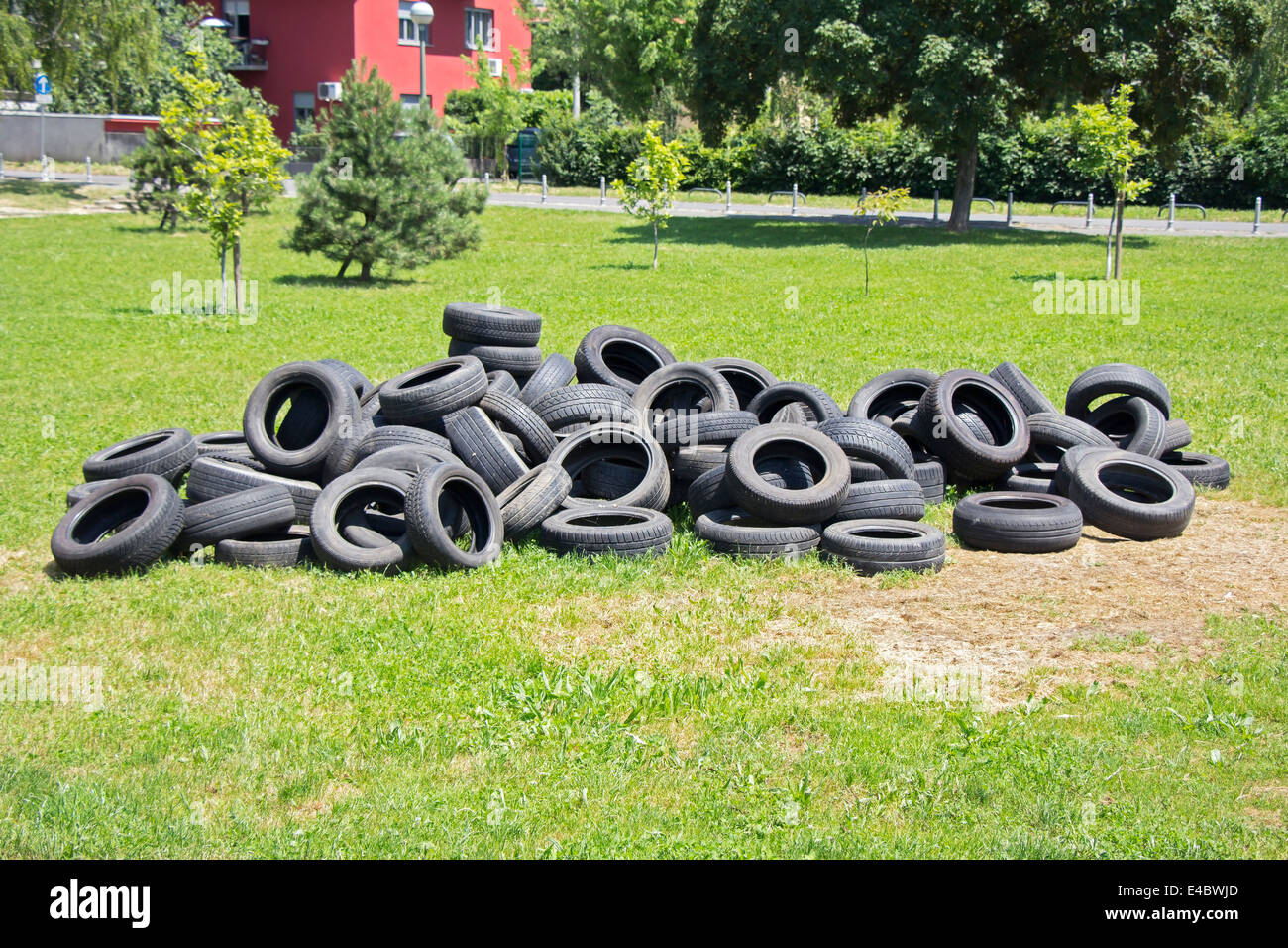 Vecchi pneumatici usati impilati sull'erba nel parco Foto Stock