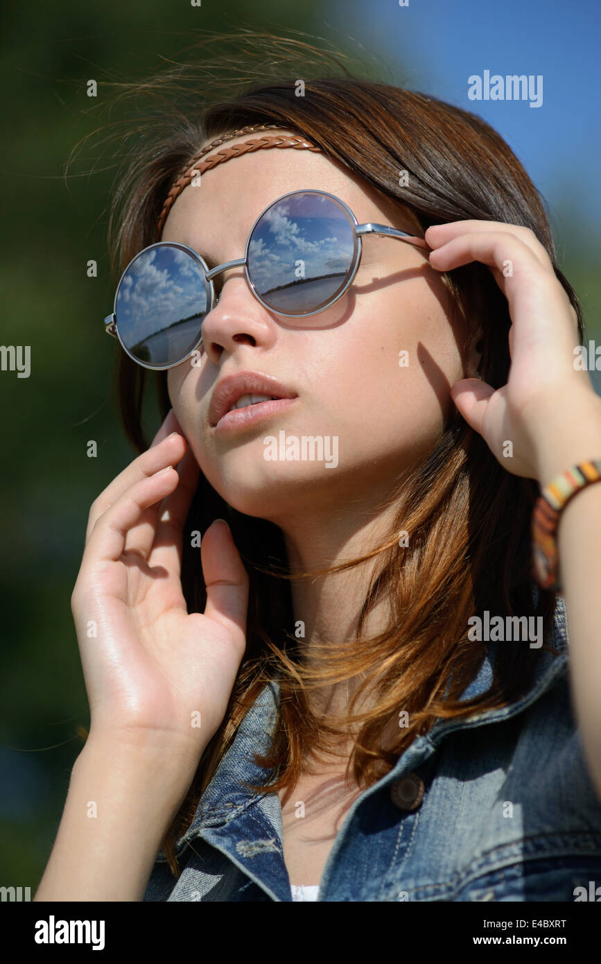 Giovane donna in mirroring di occhiali da sole Foto Stock