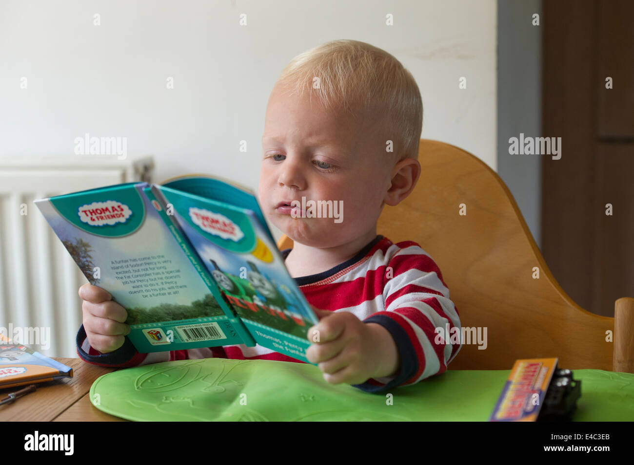 Un giovane bambino la lettura di un libro Foto Stock