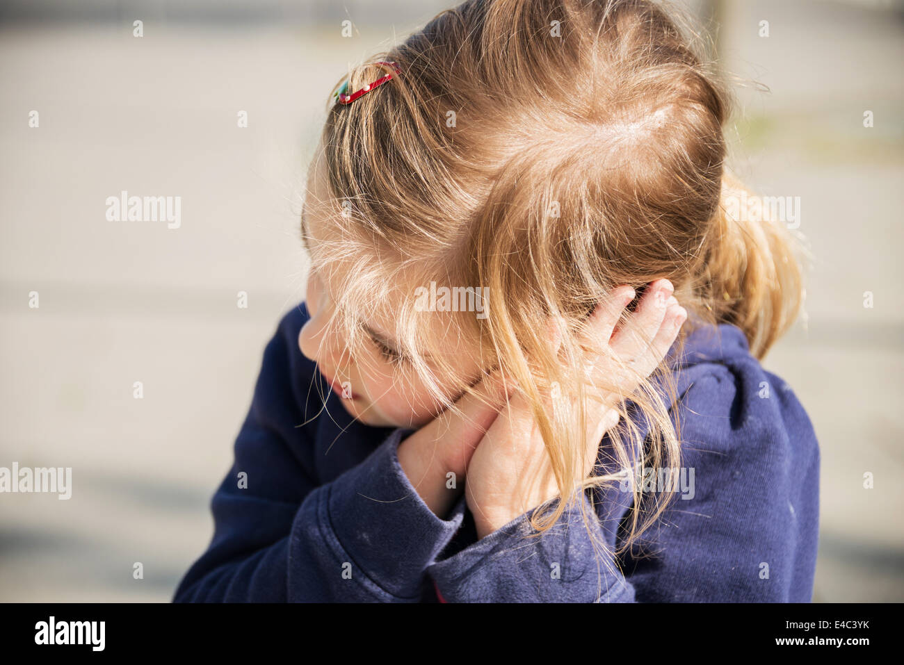 Ragazza bionda appoggiato la testa nelle mani, Monaco di Baviera, Germania Foto Stock