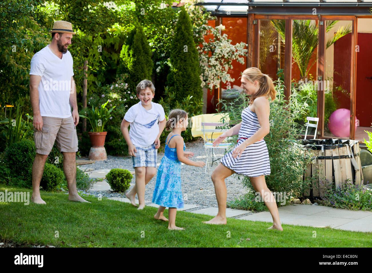 Famiglia con due bambini in giardino ingannare intorno, Monaco di Baviera, Germania Foto Stock