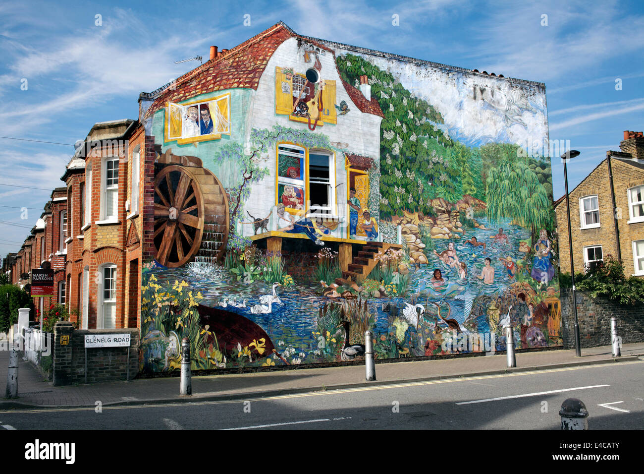 La mattina presto estate sole illumina il grande splash murale sulla parete di estremità di una casa a schiera, Brixton, Londra. Foto Stock