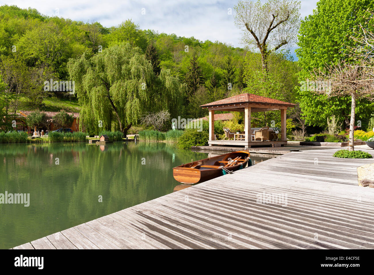A Lakeside pavilion con legno barca a remi ormeggiate dai deck Foto Stock