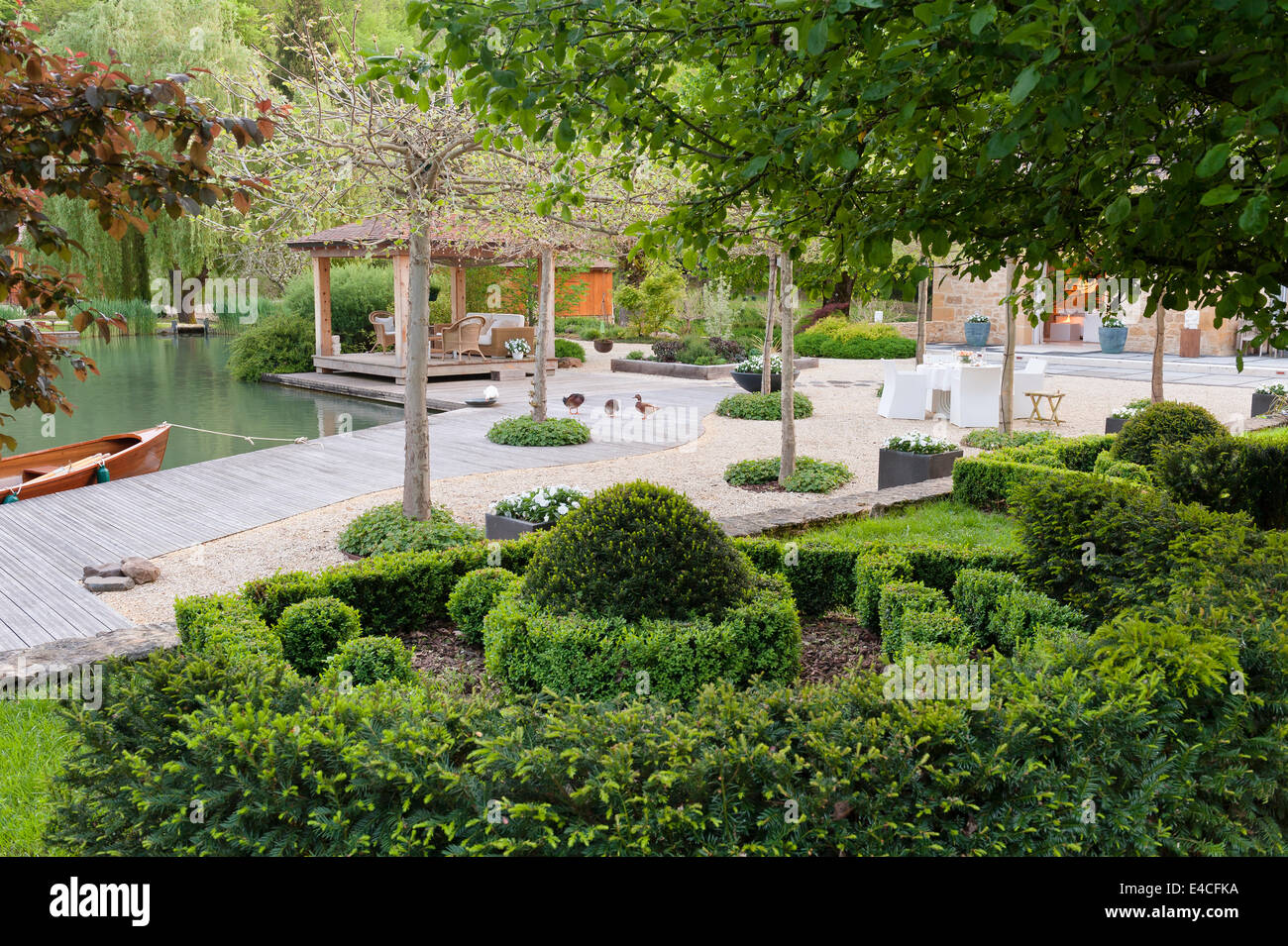 Scatola, yew e ligustro sono piantati su un pendio sopra una terrazza sul lago Foto Stock