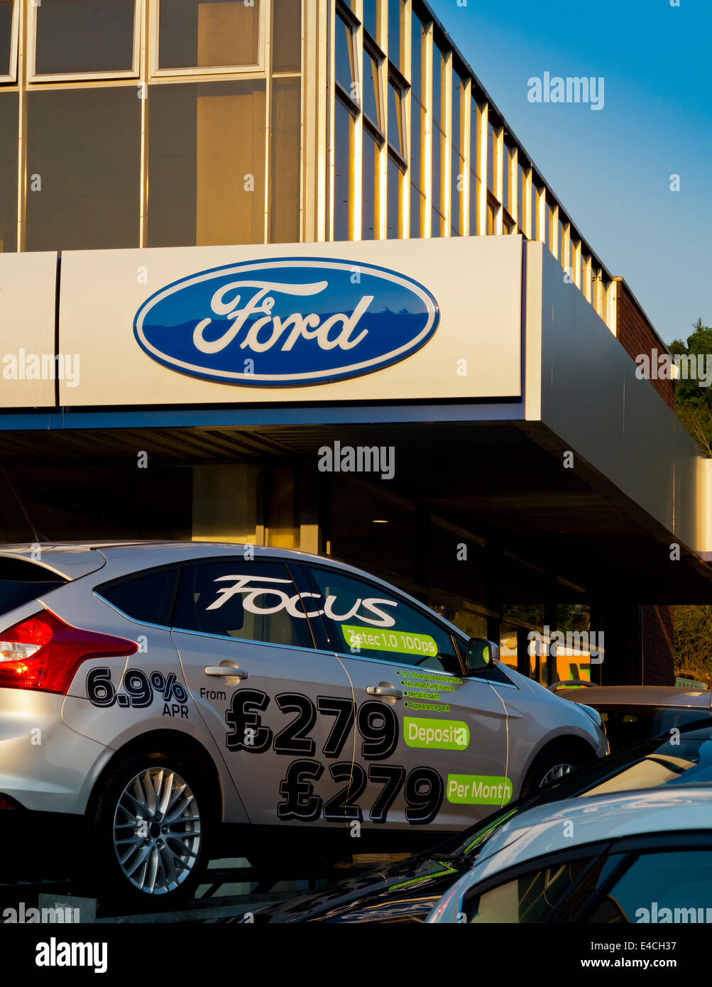 Ford Focus in vendita su un piazzale ai concessionari in Redhill Surrey in Inghilterra UK con pagamenti mensili mostrato sul lato della macchina Foto Stock