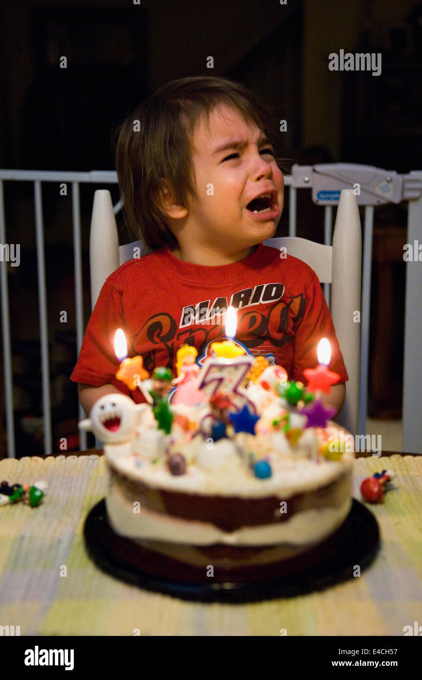 Tre anni di vecchio ragazzo gridando mentre festeggia il suo compleanno Foto Stock