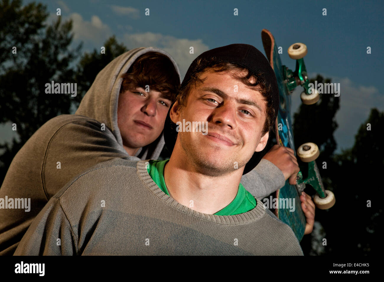 Due giovani uomini, una holding uno skateboard Foto Stock