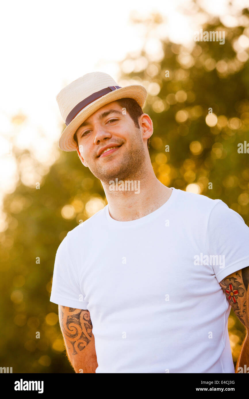 Giovane con cappello di paglia e tatuaggi sui bracci, osijek, Croazia Foto  stock - Alamy