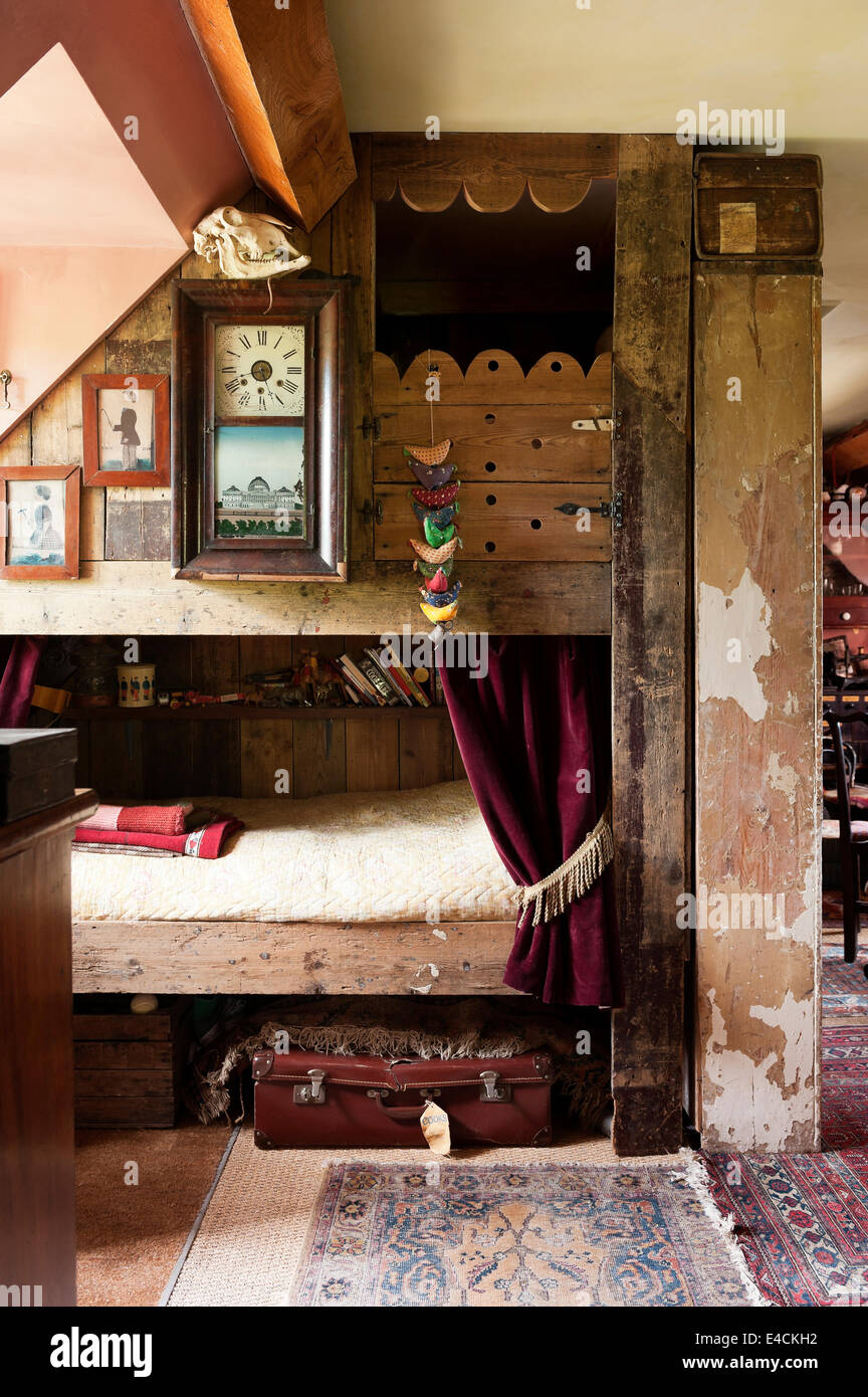 Letti a castello fatto di legno di recupero con sbiadite immagini incorniciate e vecchio orologio Foto Stock
