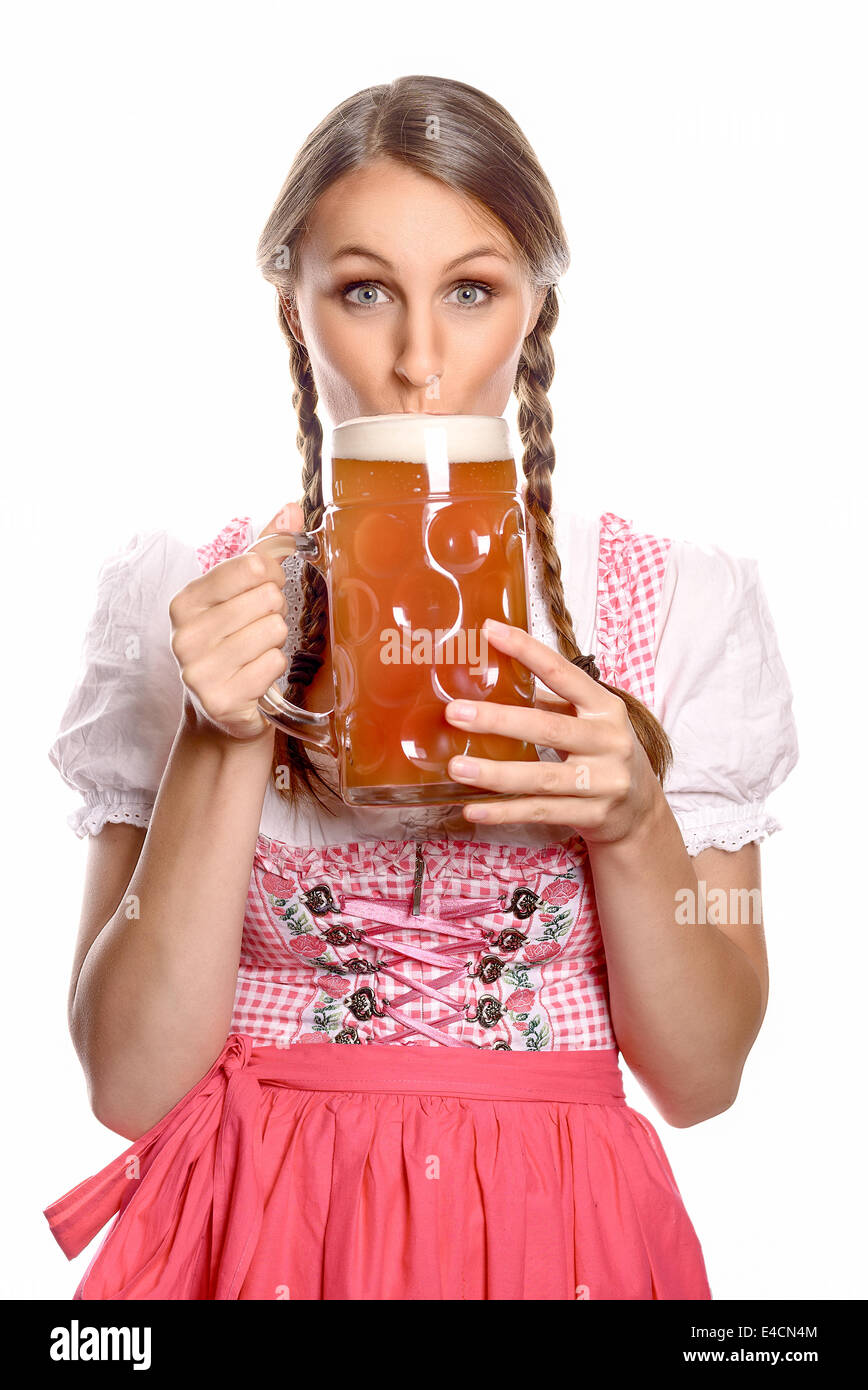 Attraente giovane donna con i capelli in trecce che indossa un vestito di bere la birra da un vetro molto grandi il boccale con un look di ant Foto Stock