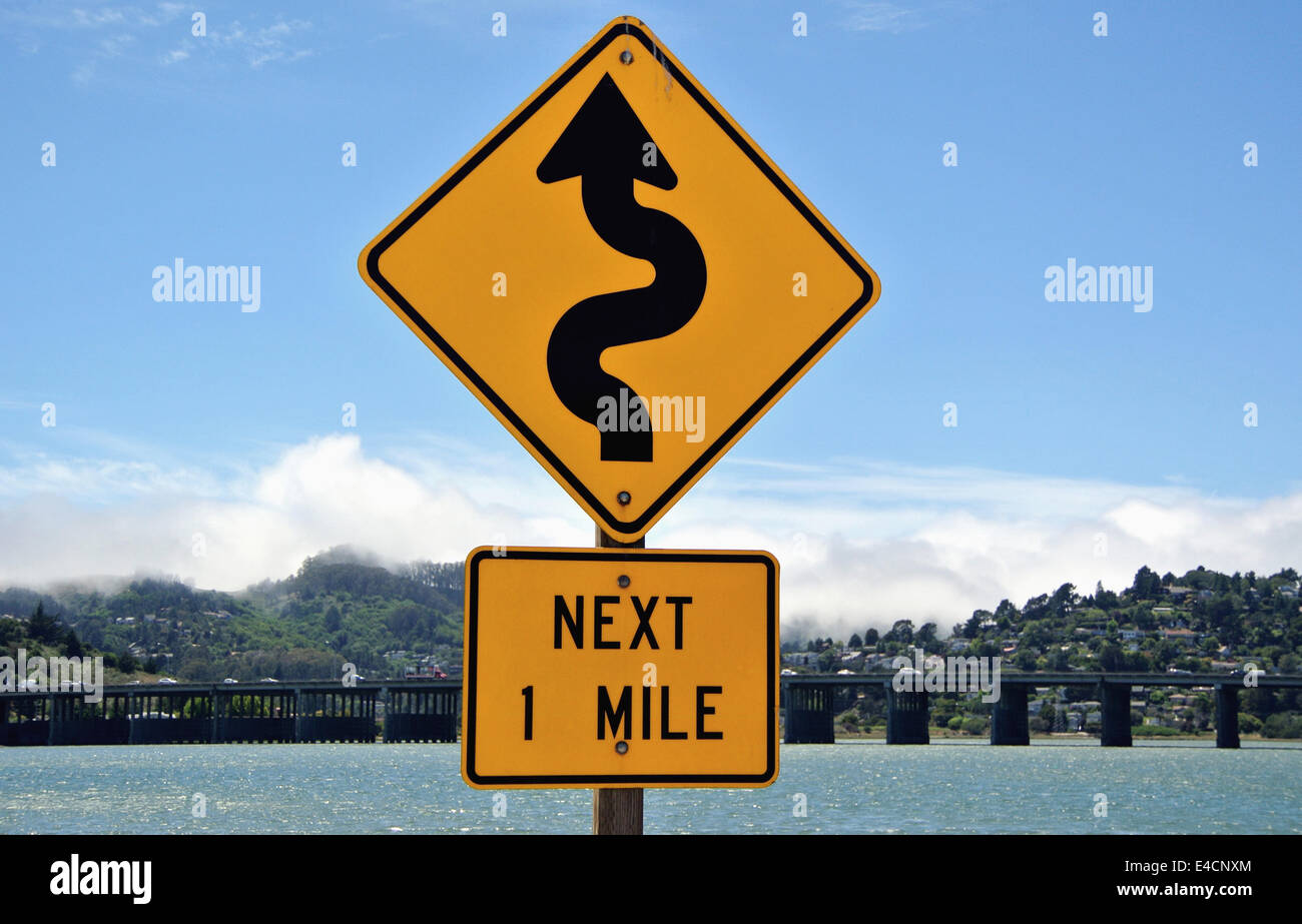 Winding Road Sign in Mill Valley in California con la vista del ponte sull'autostrada 101 a Marin County Foto Stock