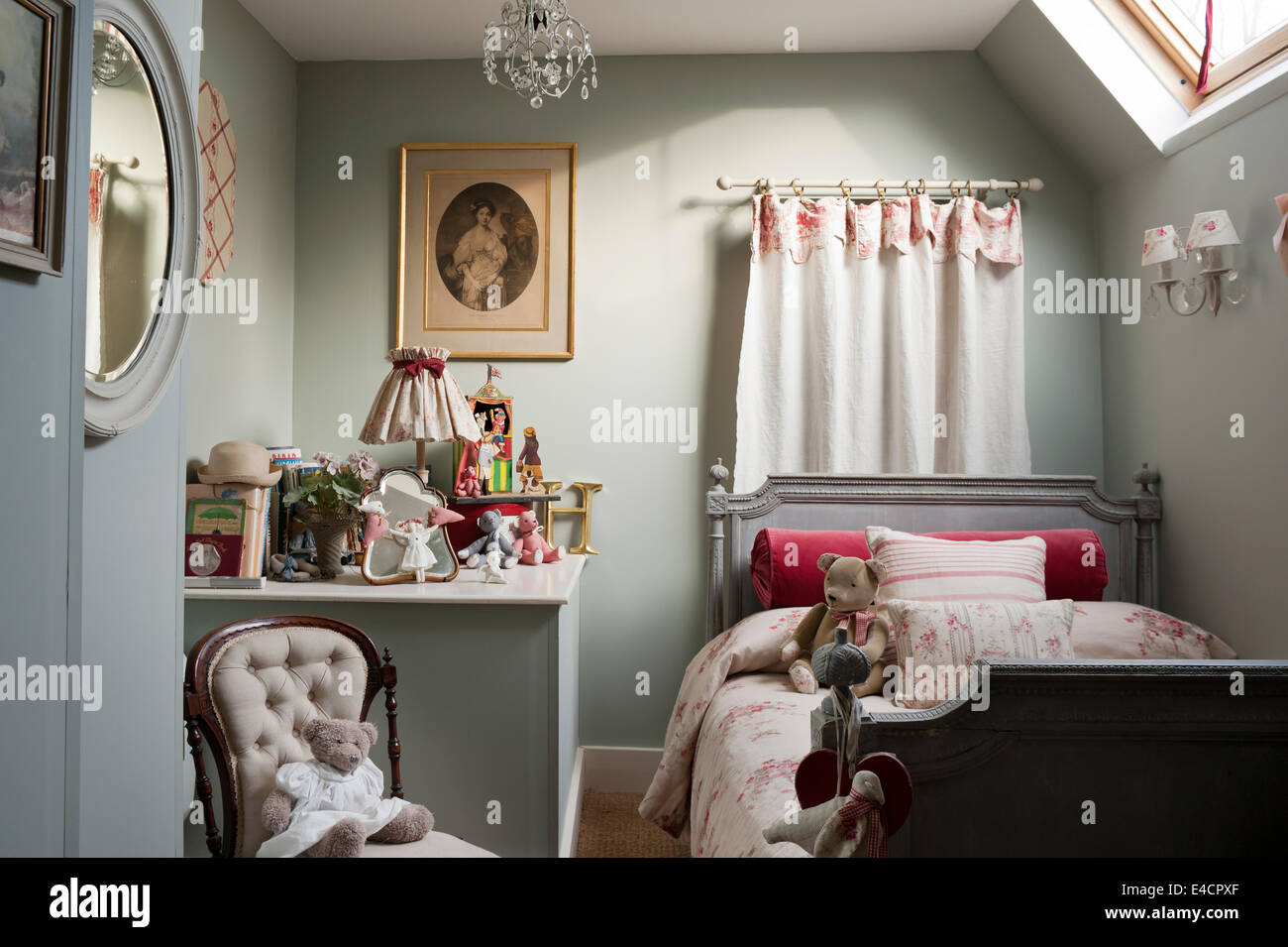Tessuto Isobella da Kate Forman sul piccolo letto antico in camera da letto per i bambini con abbottonata sedia e un assortimento di giocattoli Foto Stock