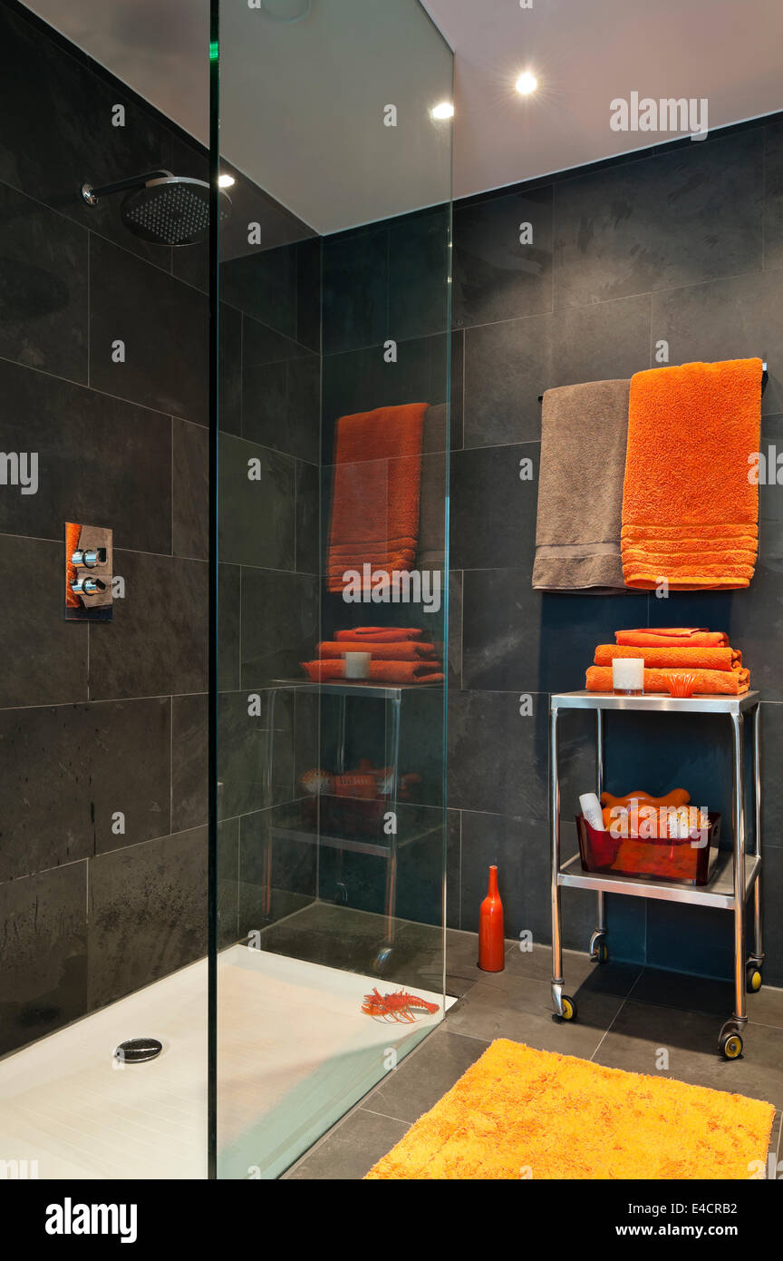 Arancio brillante gli asciugamani in bagno con piastrelle di ardesia Foto Stock