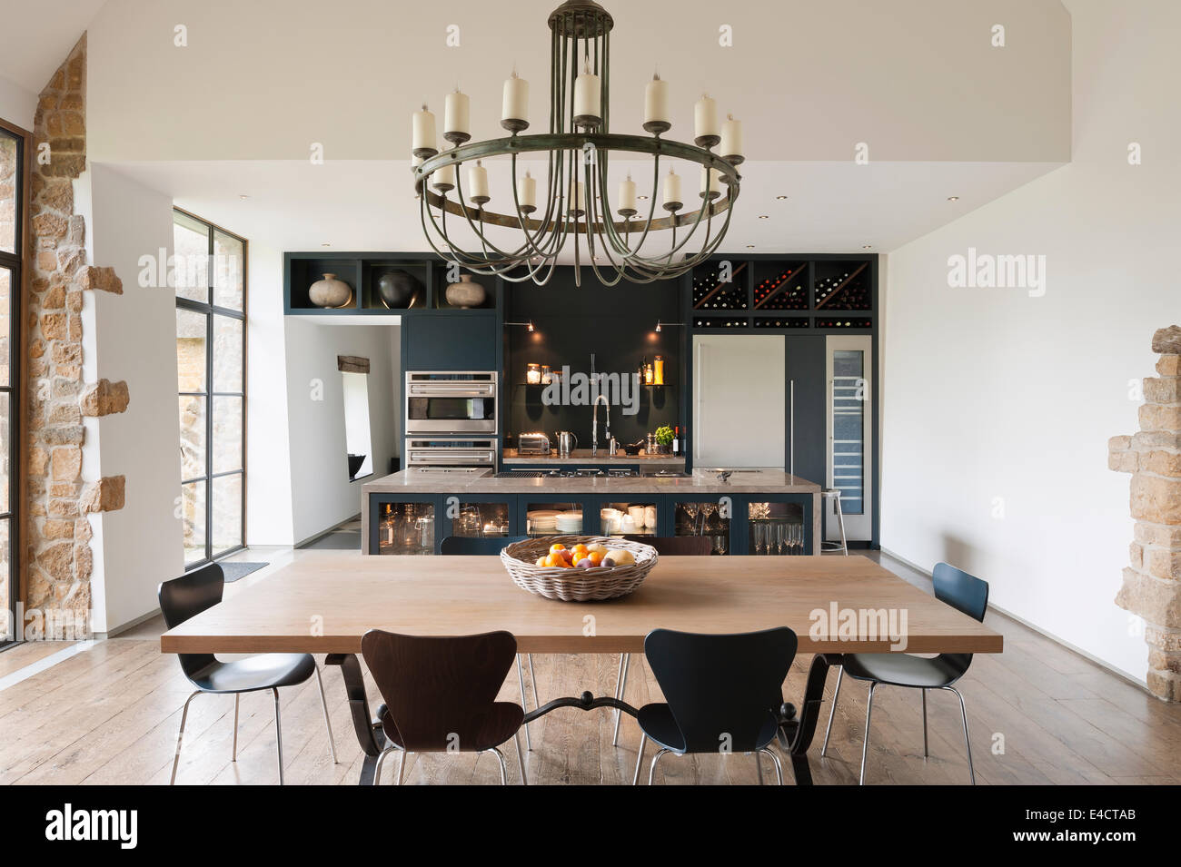 Verdigris lampadario pende al di sopra di una quercia sormontata tavolo da pranzo in cucina con unità dipinte di blu/grigio Foto Stock