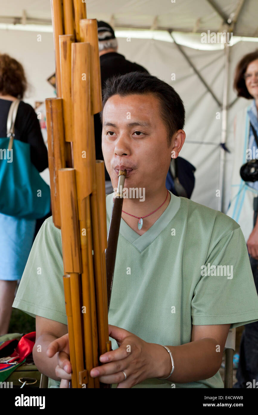 L'uomo gioca un bambù artigianali Lusheng armonica a bocca Foto Stock