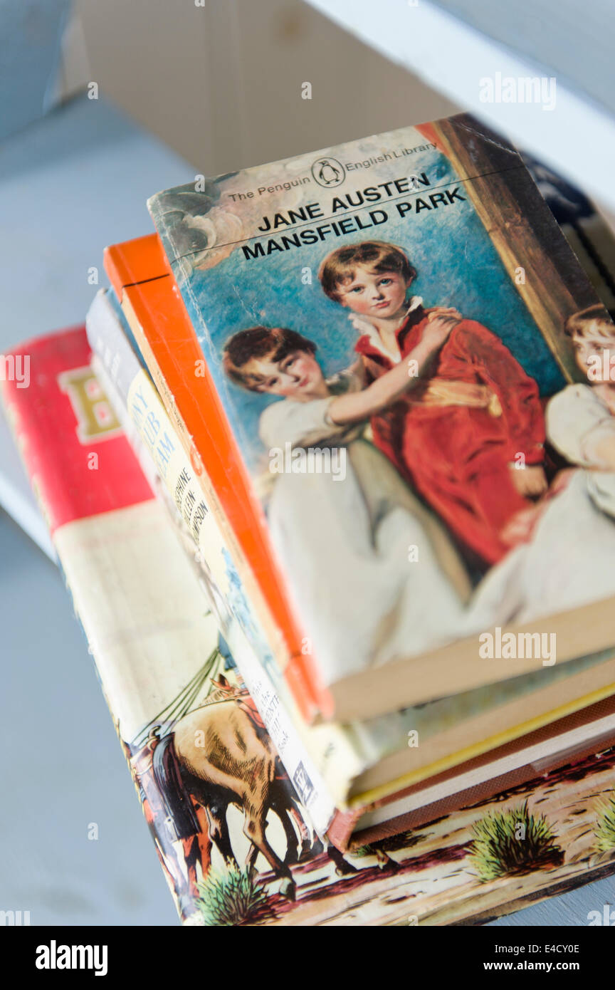 Una copia di Jane Austen's Mansfield Park sulla sommità di una pila di altri libri vintage Foto Stock