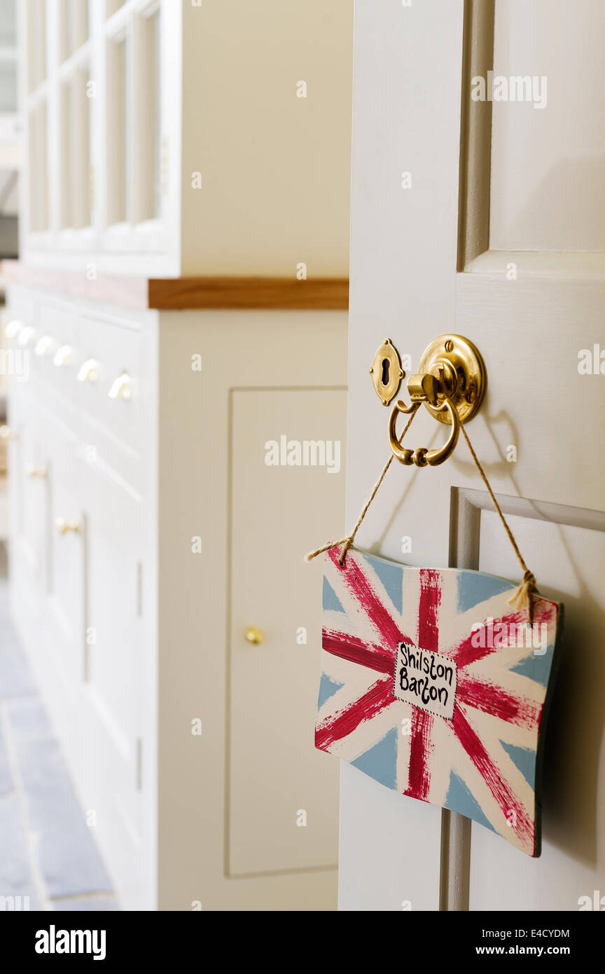 Un Union Jack segno di stile pende da un ottone maniglia della porta Foto Stock