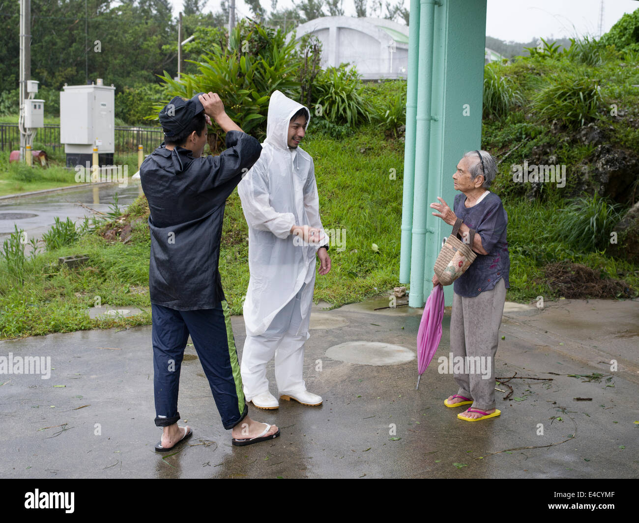 Typhoon Neoguri Okinawa, in Giappone. 9 luglio 2014, le piogge torrenziali e le inondazioni continuano come isole inizia il ripristino. Il 93-anno-vecchio Tokumura san capi fuori dopo il tifone al villaggio ufficio. Lei dice che ha visto grandi tifoni prima. Credito: Chris Willson/Alamy Live News Foto Stock