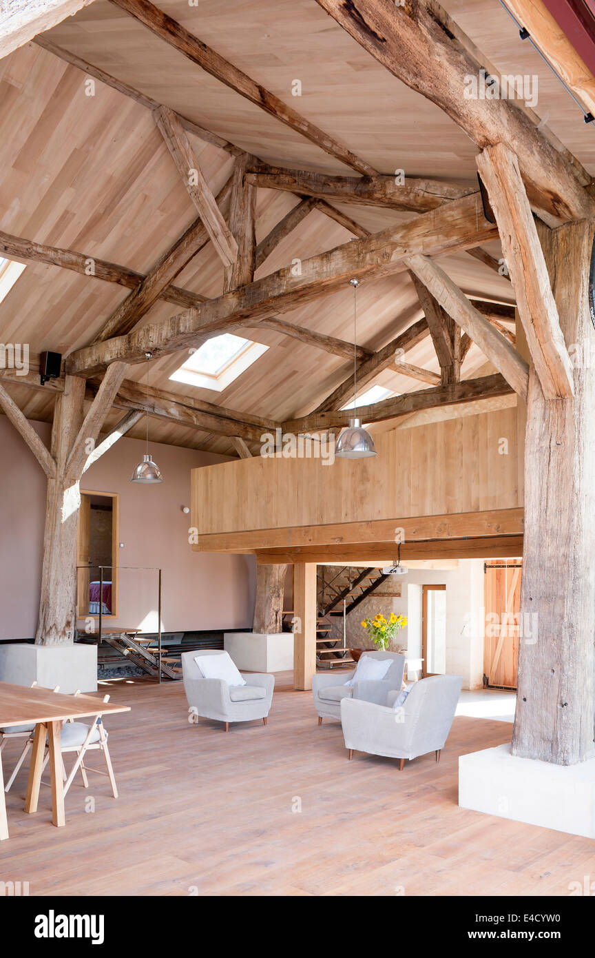 Barn convertito con travi in legno originali, grigio poltrone e mezzanine Foto Stock