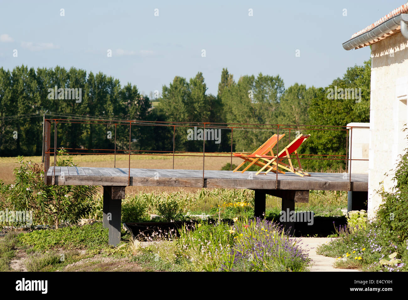 Coppia di sedie a sdraio su bassa ponte in legno di quercia con balaustra in ferro e viste rurali Foto Stock