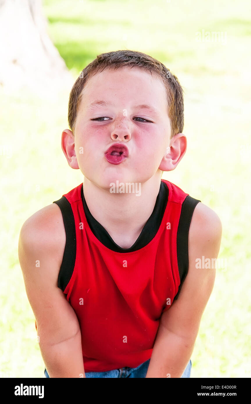 Carino piccolo ragazzo essere giocoso e facendo facce buffe Foto Stock