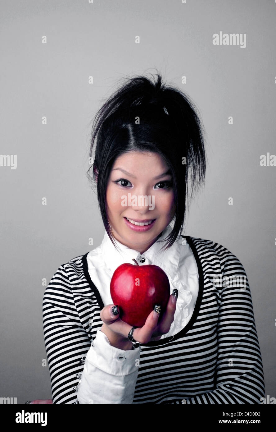 Donna asiatica azienda apple. Ella è giapponese e aveva 23 anni al momento di sparare. Foto Stock