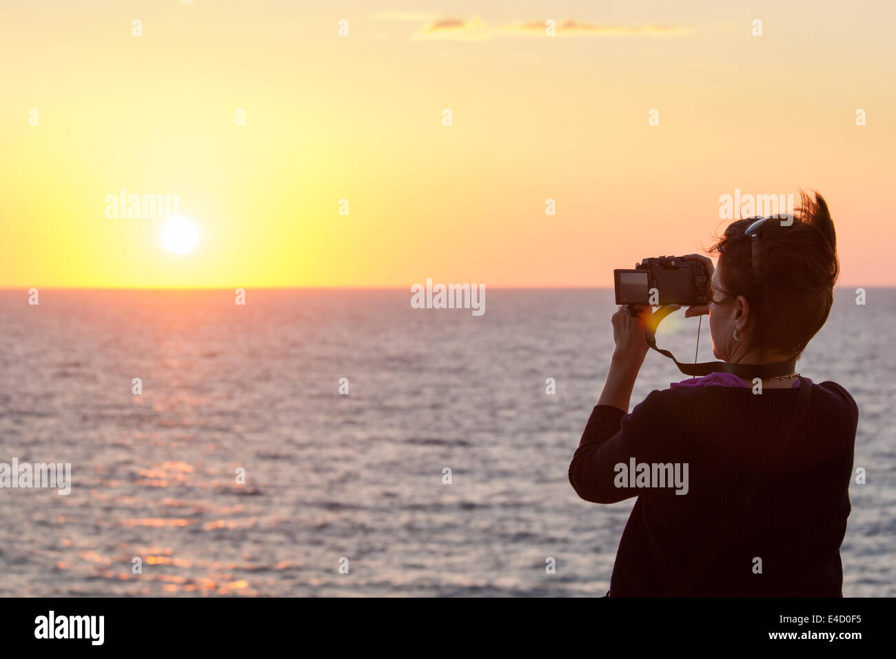 Un turista fotografie il tramonto sul Pacifico in Mazatlan, Sinaloa, Messico. Foto Stock