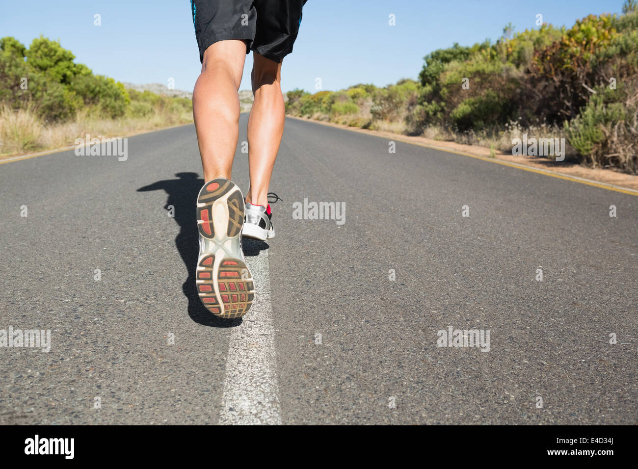 Montare l'uomo jogging sulla strada aperta Foto Stock