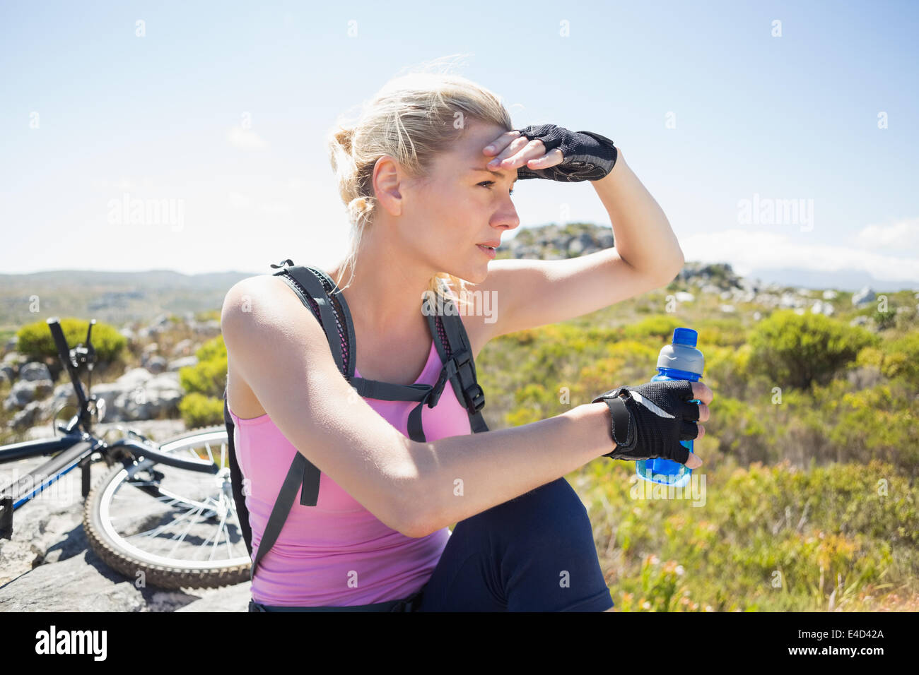 Montare piuttosto ciclista prendendo una pausa sul picco roccioso Foto Stock