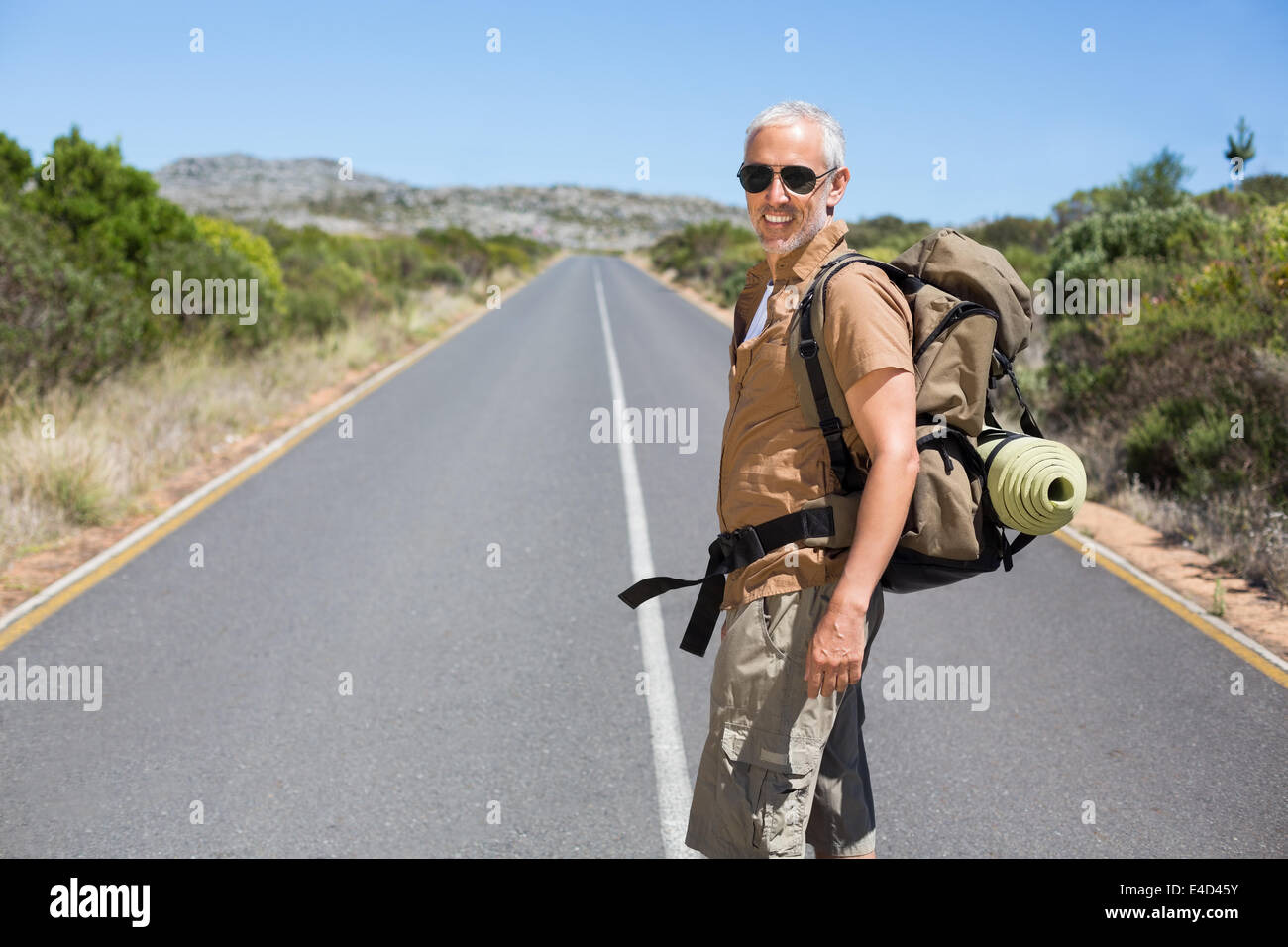 Belli gli escursionisti a piedi sulla strada e sorridente in telecamera Foto Stock