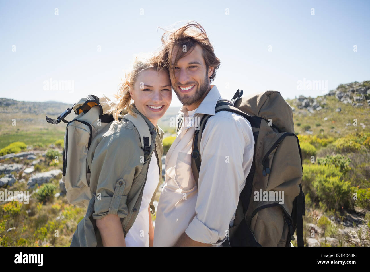 Escursionismo giovane in piedi sul terreno di montagna sorridente in telecamera Foto Stock