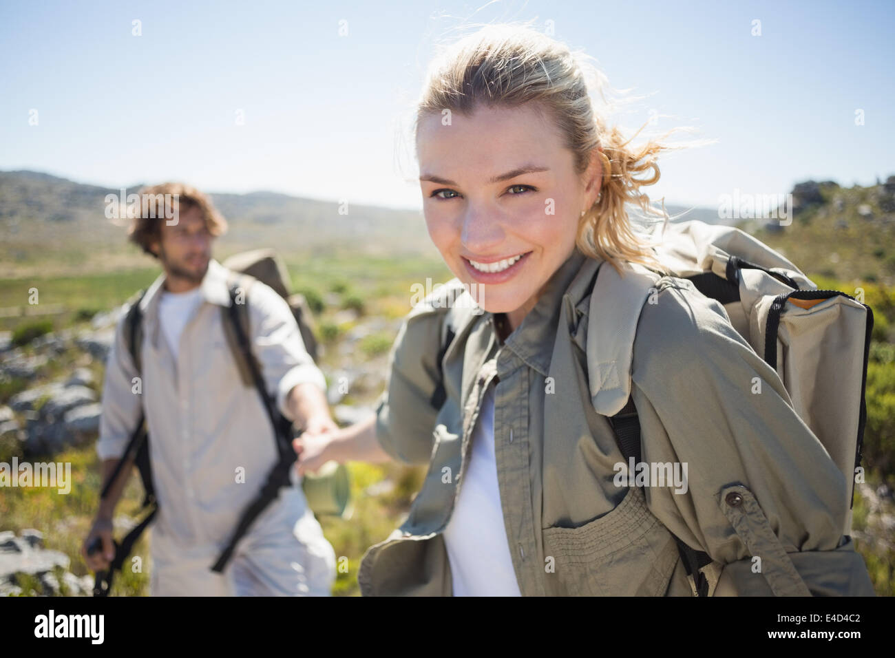 Escursionismo giovane in piedi sul terreno di montagna donna sorridente in telecamera Foto Stock