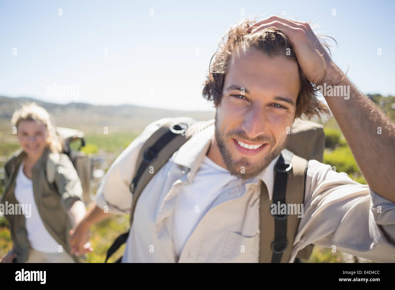 Escursionismo giovane camminando sul terreno di montagna sorridente in telecamera Foto Stock
