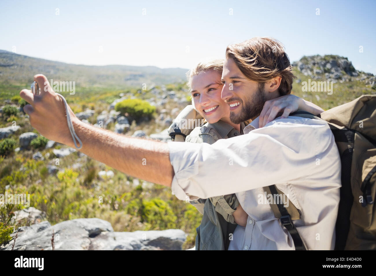 Escursionismo giovane in piedi sul terreno di montagna prendendo un selfie Foto Stock