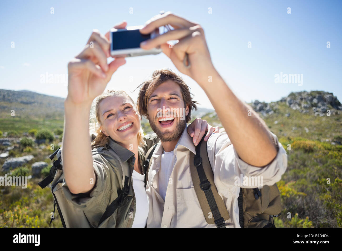 Escursionismo giovane in piedi sul terreno di montagna prendendo un selfie Foto Stock