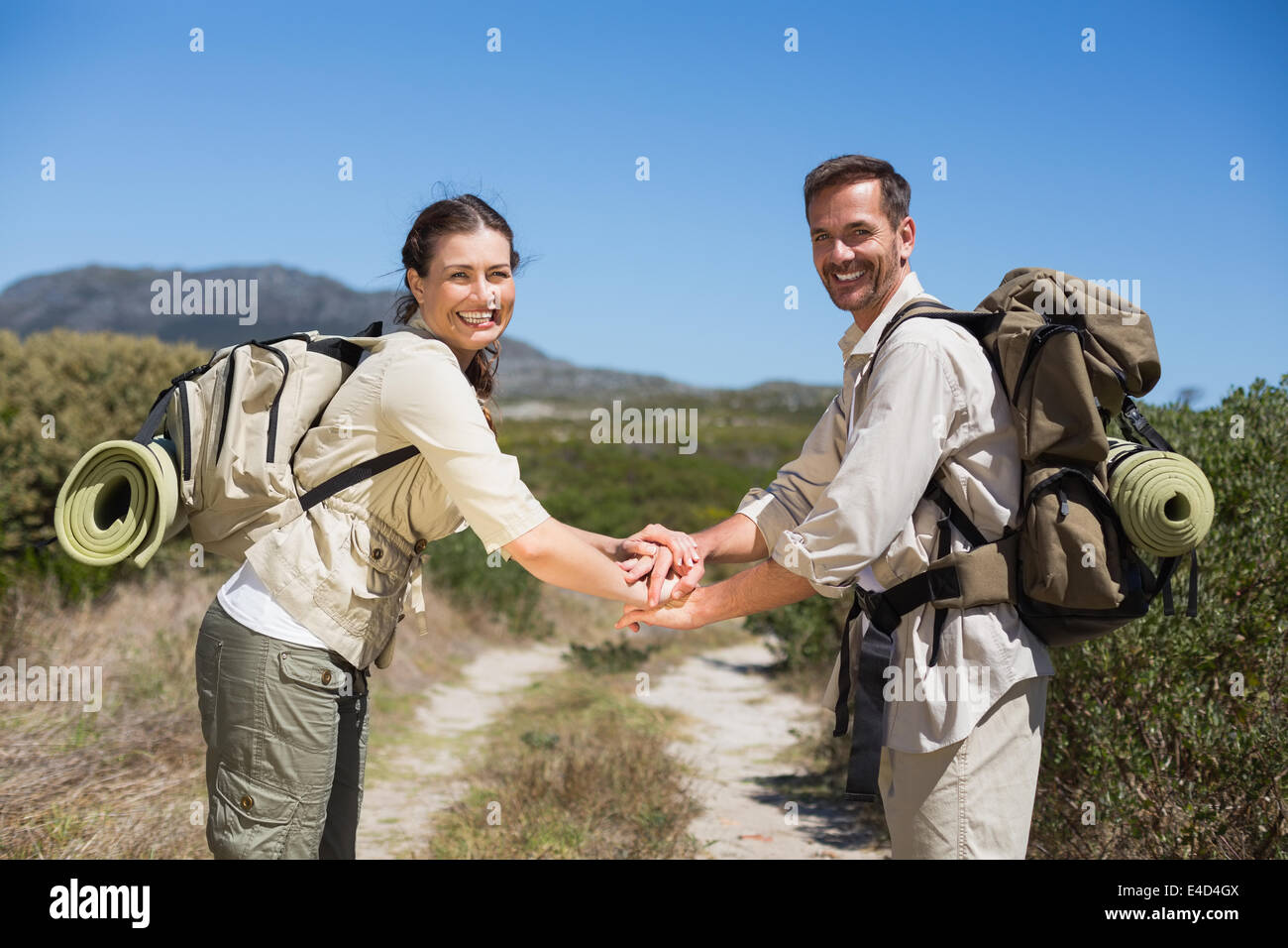 Escursionismo coppia mettendo le mani insieme sul sentiero del paese Foto Stock