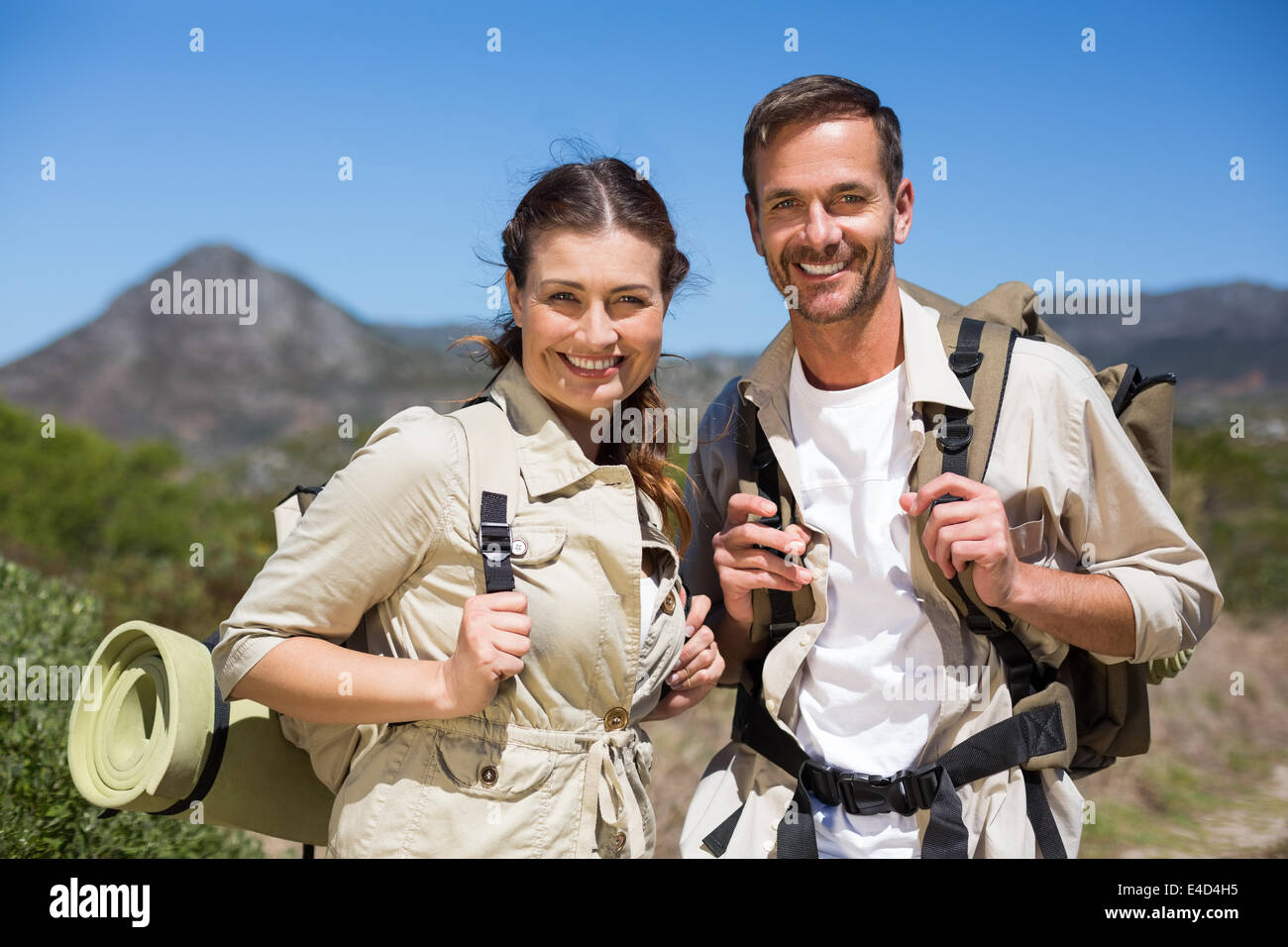 Escursionismo giovane in piedi e sorridente alla fotocamera sul terreno del paese Foto Stock