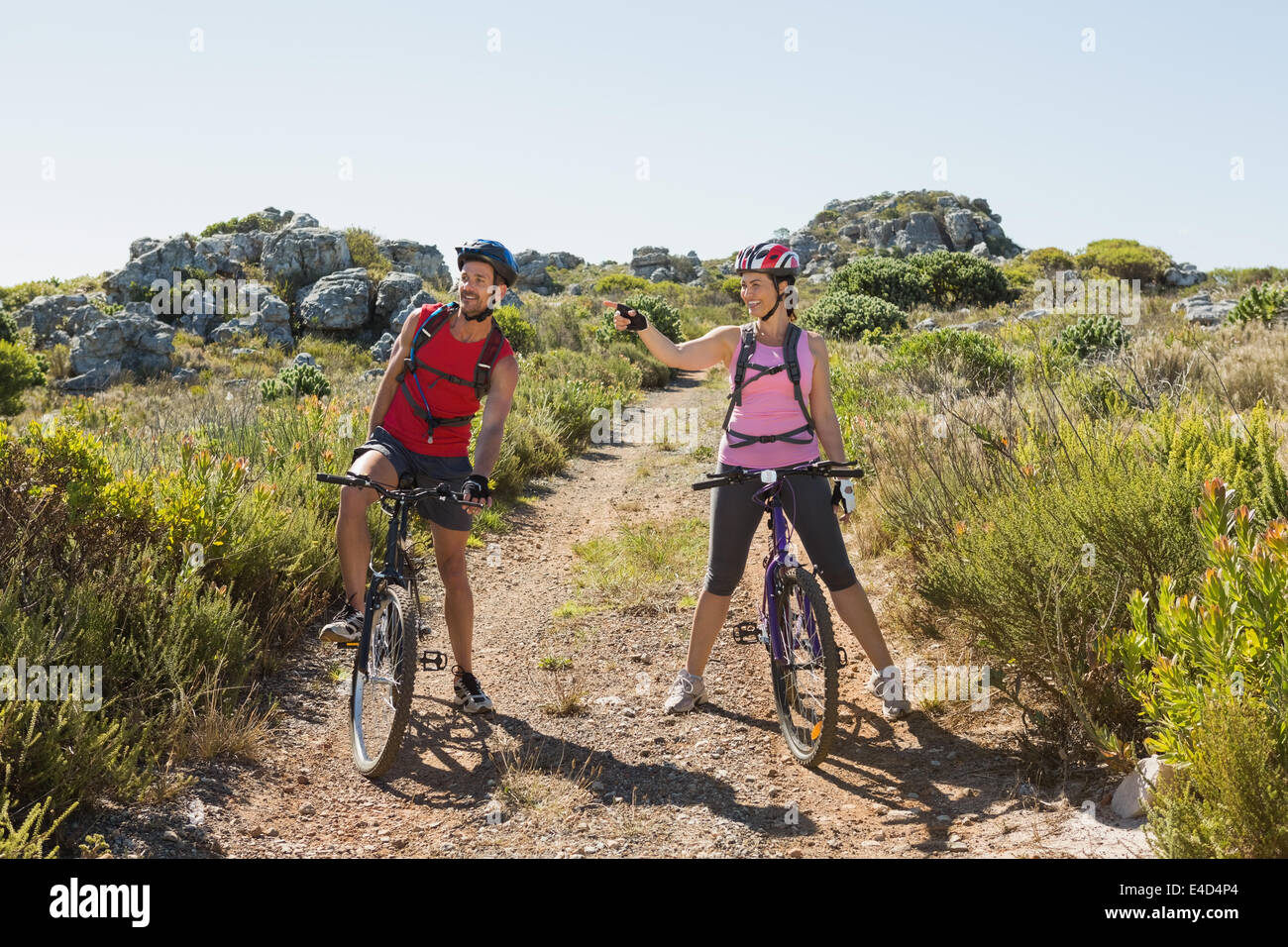 Coppia attiva escursioni in bicicletta nelle campagne guardando al lato Foto Stock