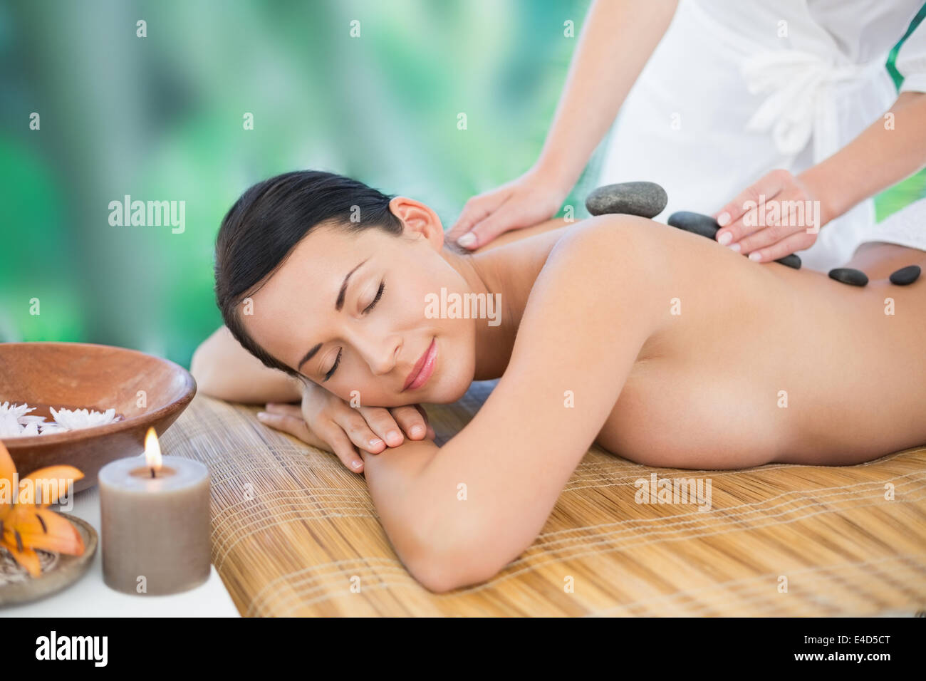 Bella bruna godendo di un massaggio con pietre calde Foto Stock