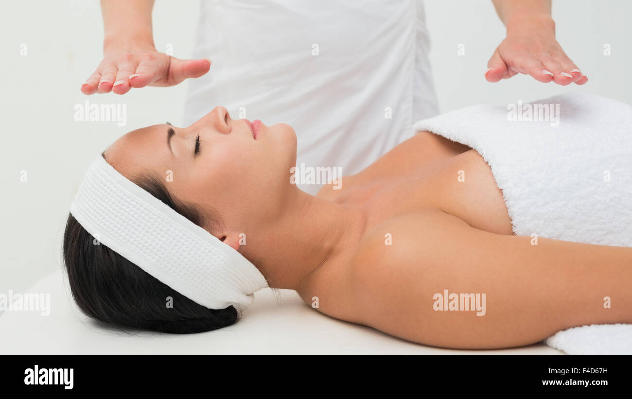 Tranquillo brunette ricevendo la terapia reiki Foto Stock