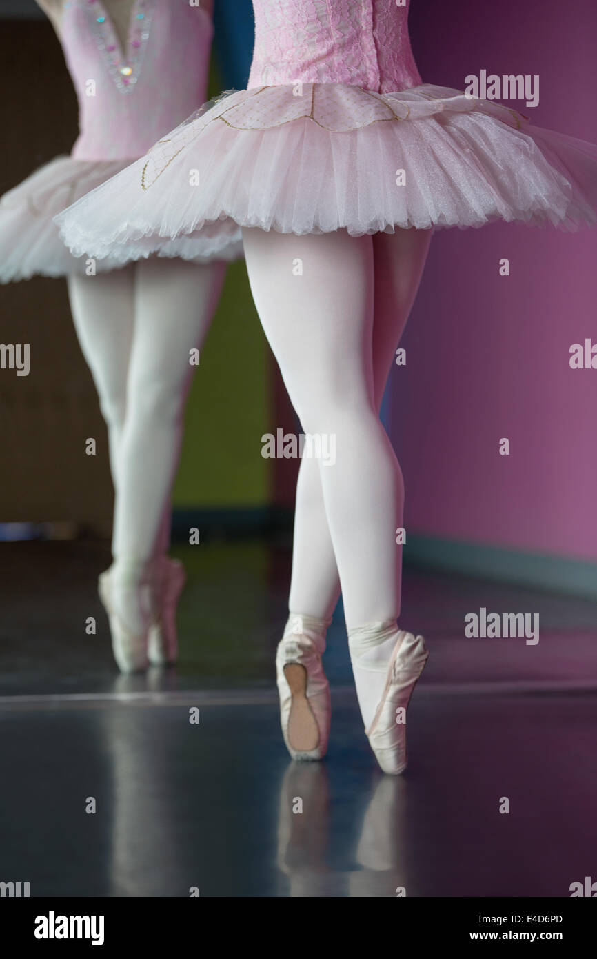 Graziosa ballerina in piedi en pointe nella parte anteriore dello specchio Foto Stock