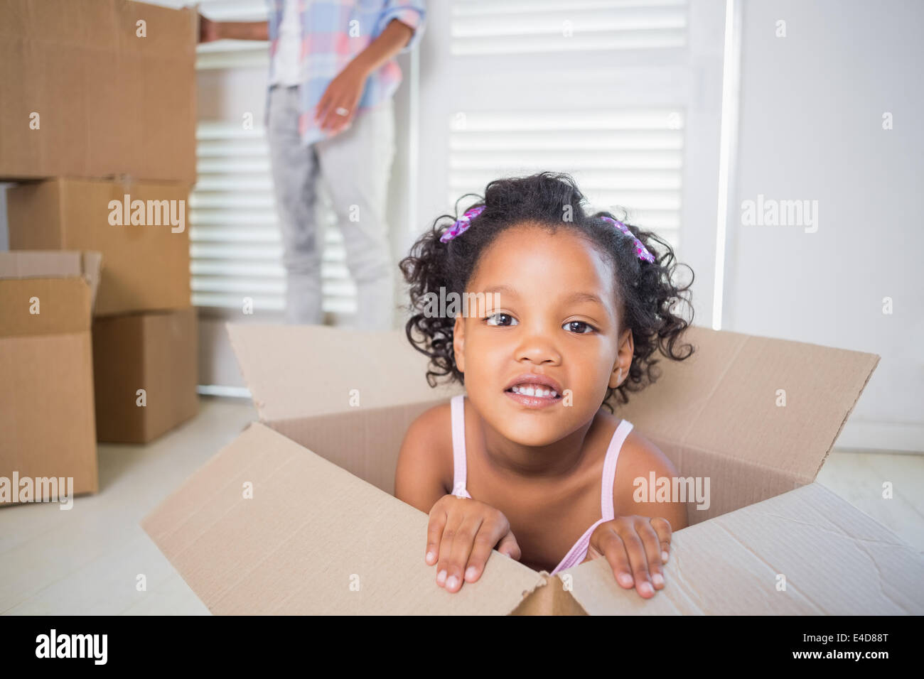 Carino figlia seduta nella scatola di movimentazione Foto Stock