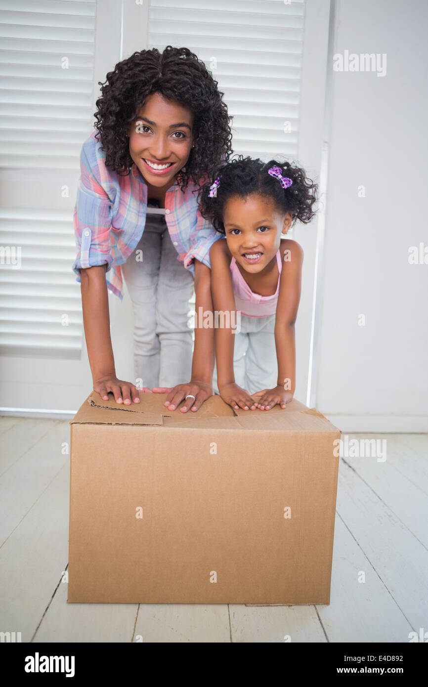 Carino figlia disimballaggio scatole in movimento con la sua madre Foto Stock