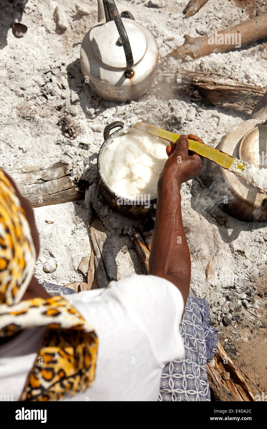 Kavango donna preparando la tradizionale farina di mais piatto ugali o Pap sul fuoco aperto, Okavango Delta, Botswana, Africa Foto Stock
