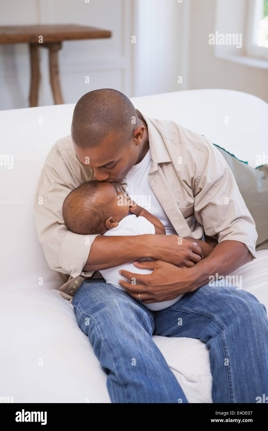 Padre felice di trascorrere del tempo con il bambino sul lettino Foto Stock