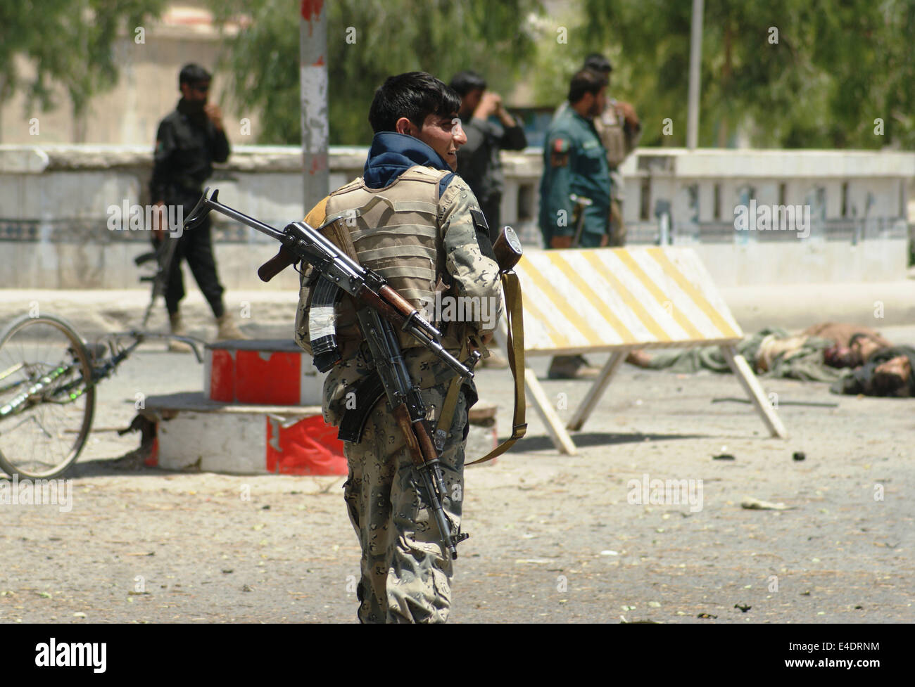 A Kandahar, Afghanistan 9 Luglio, 2014. Soldati afgani ispezionare il sito di un attentato nella provincia di Kandahar in Afghanistan meridionale, 9 luglio 2014. Gli attacchi massicci, compresi gli attentati suicidi, lanciato da militanti talebani contro il quartier generale della polizia e governatore provinciale ufficio a Kandahar city, la capitale della provincia di Kandahar, 450 km a sud di Kabul Mercoledì, ucciso 31 persone di cui 22 agli aggressori e feriti altri nove, polizia provinciale Abdul Raziq detto. Credito: Arghand/Xinhua/Alamy Live News Foto Stock