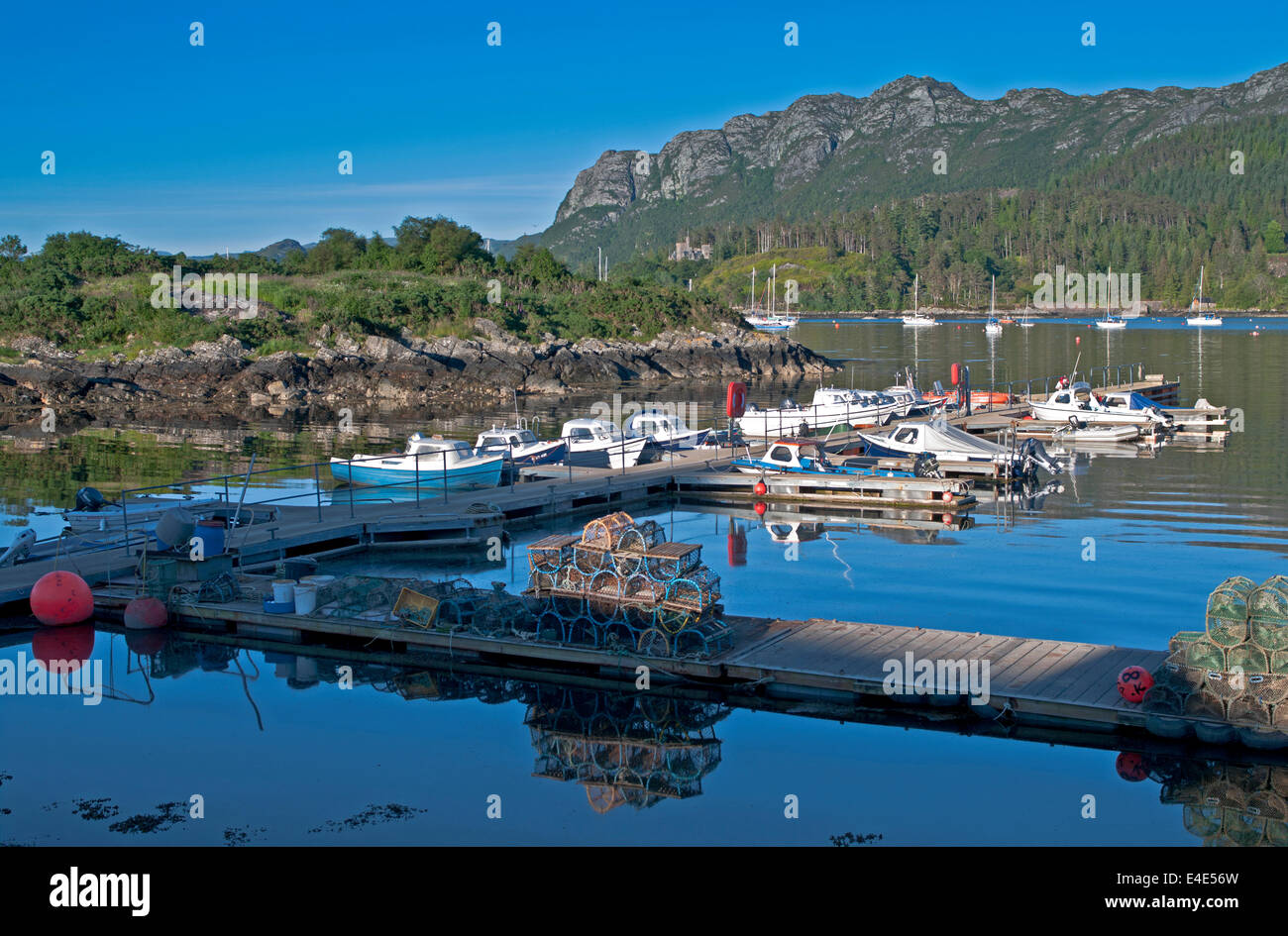 Barche ormeggiate e astice cantre impilati su pontili a Plockton Harbour, Loch Carron, Wester Ross, Highlands scozzesi Scotland Regno Unito Foto Stock