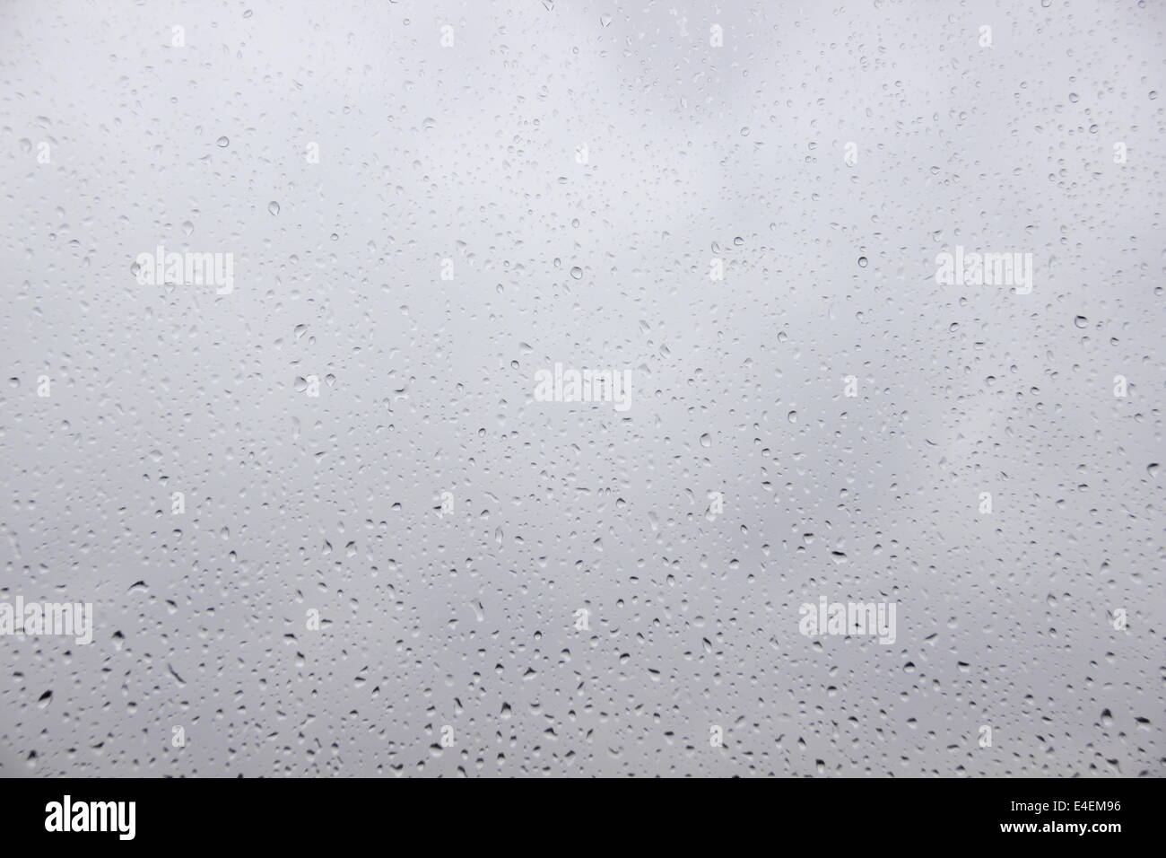 Gocce di pioggia su una finestra con heavy rain al di fuori Foto Stock