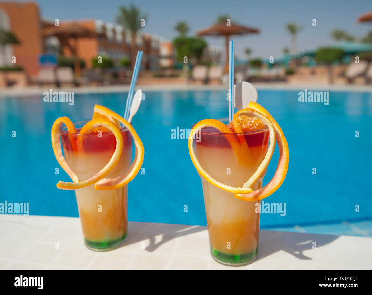 Due bicchieri di cocktail drink di frutta sulla tavola da hotel tropicale e piscina Foto Stock