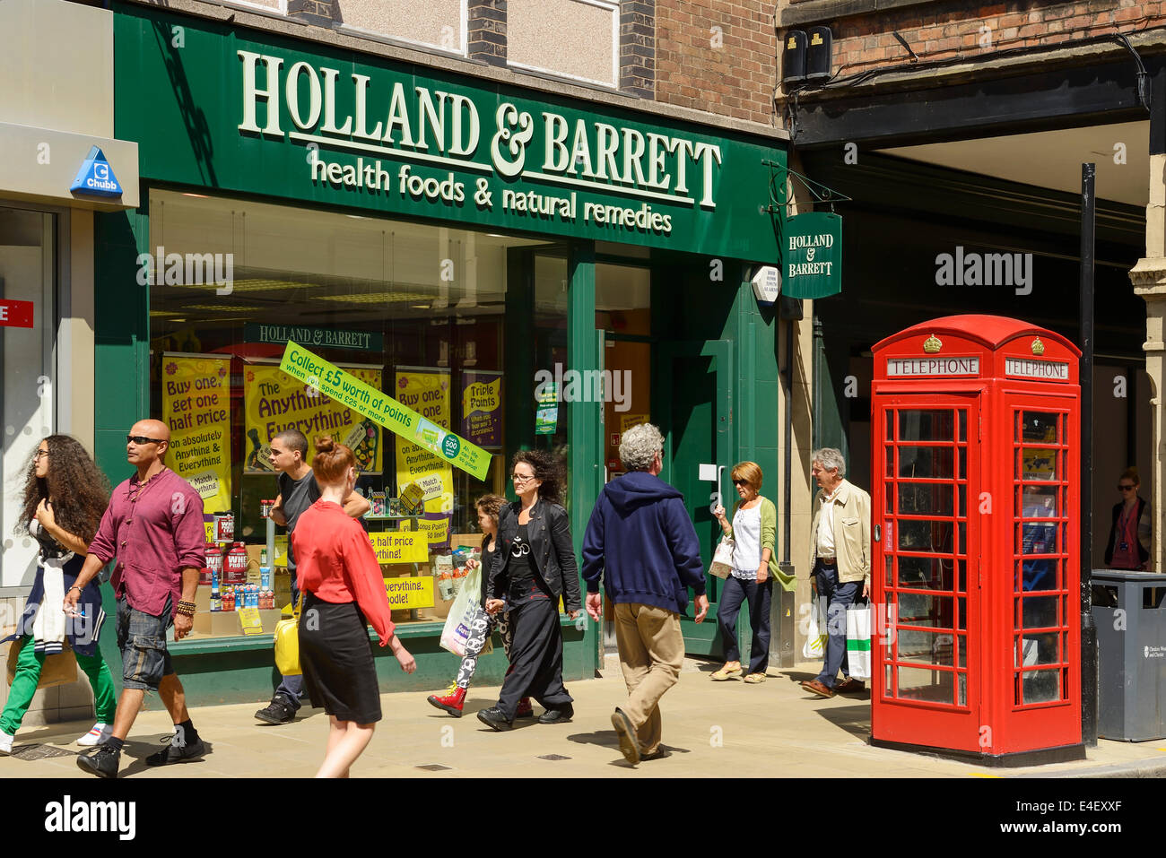 Gli amanti dello shopping nella parte anteriore di un Holland e Barrett store in Chester city centre REGNO UNITO Foto Stock